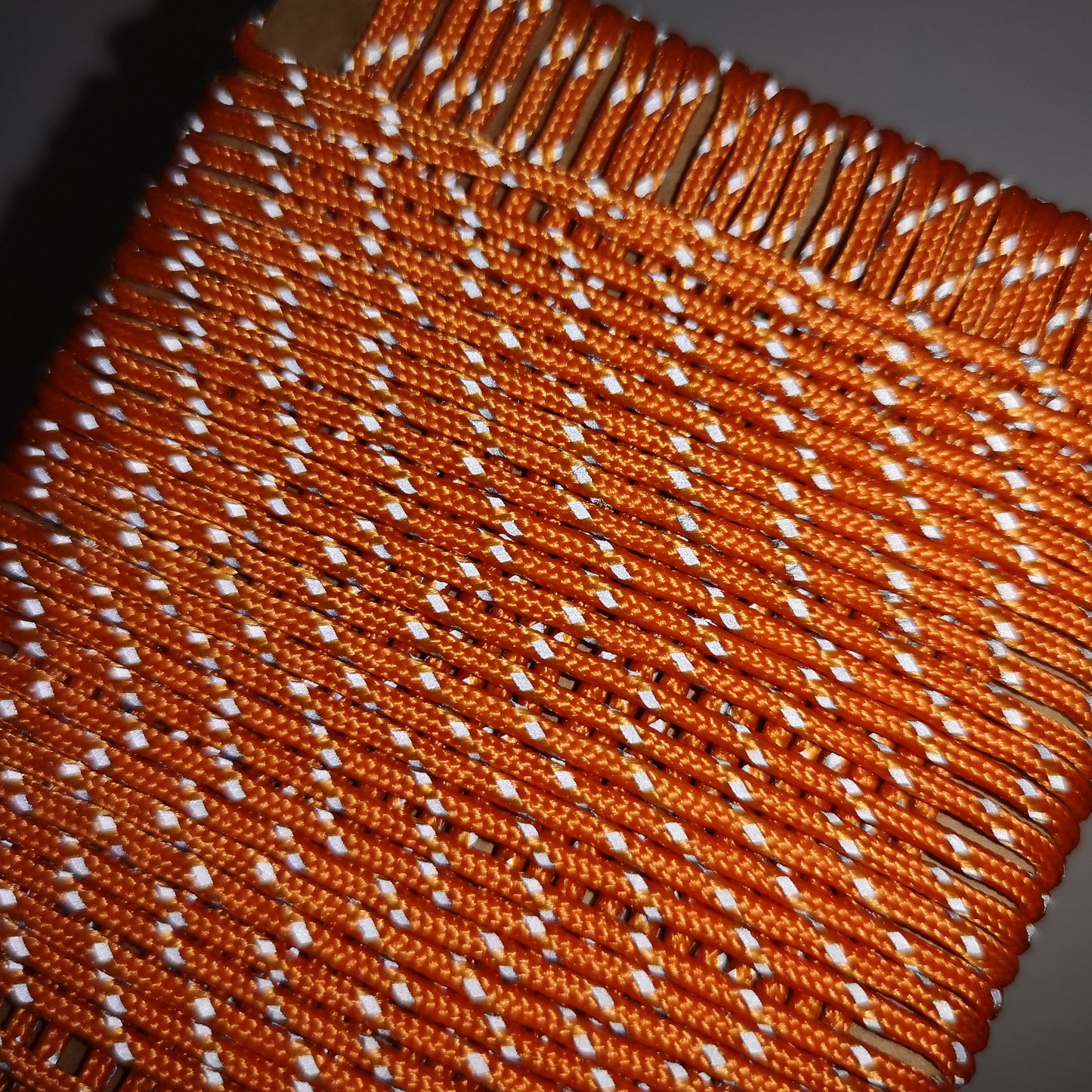 Close-up of orange and white woven fabric with a dark background