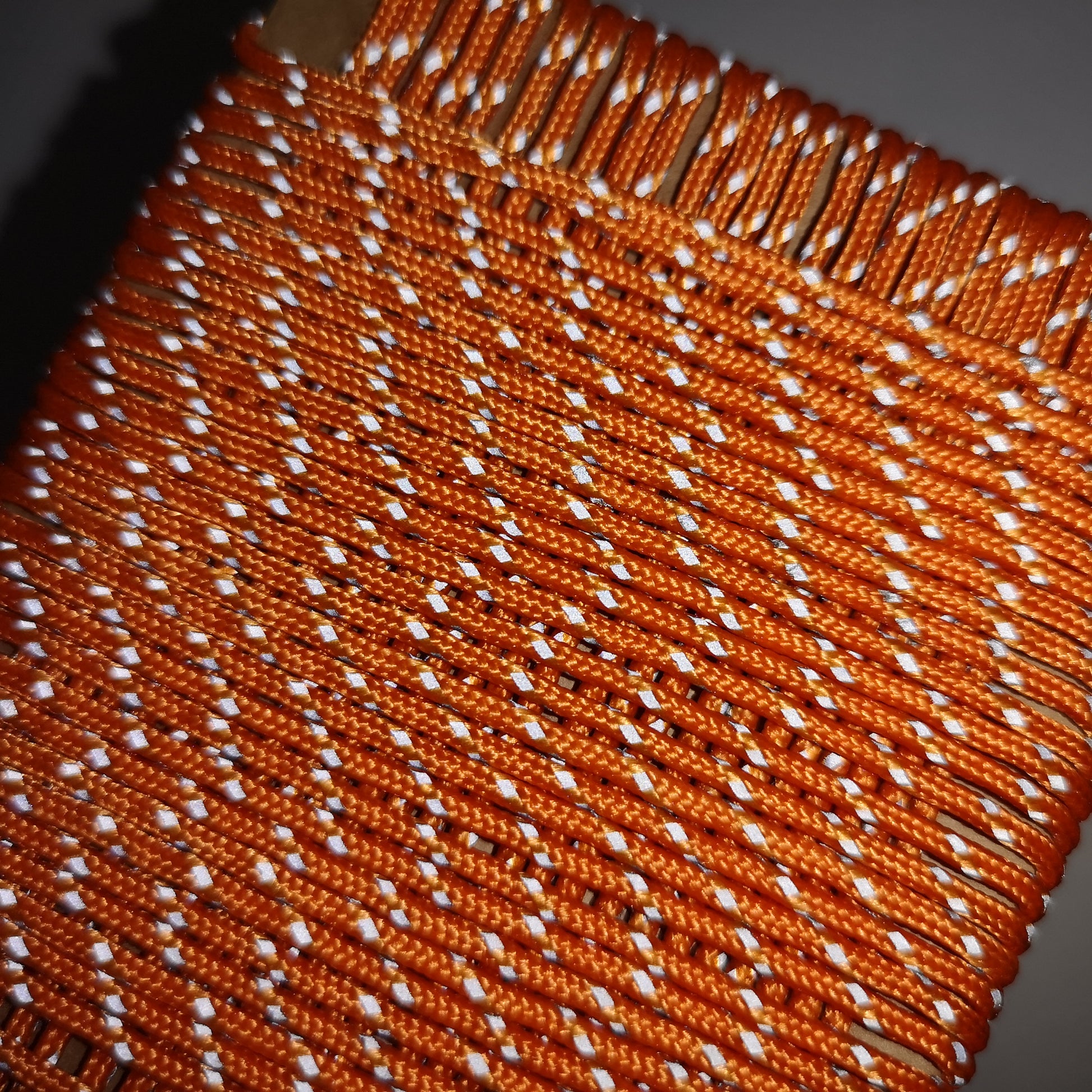 Close-up of orange and white woven fabric with a dark background