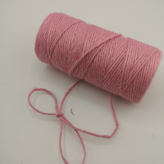 Pink jute twine roll on a white background